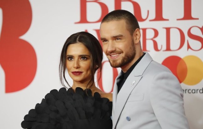 Cheryl and Liam Payne on the red carpet. She wears black dress and he wears light blue suit.