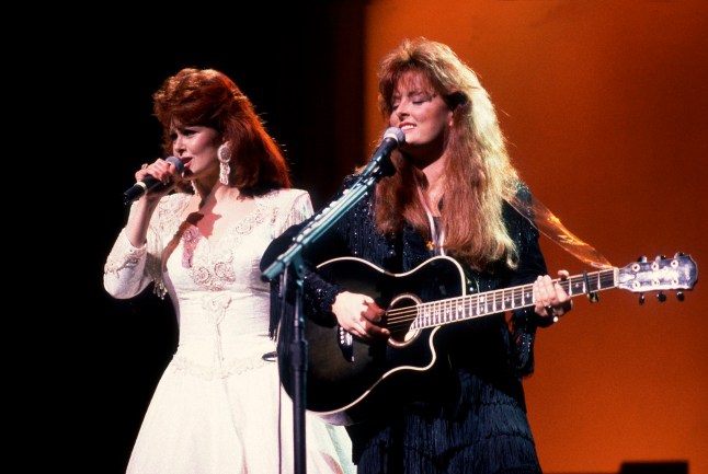 Country music duo the Judds, with Naomi Judd (left) and her daughter Wynonna, perform onstage, Chicago, Illinois, February 1, 1991. (Photo by Paul Natkin/Getty Images)